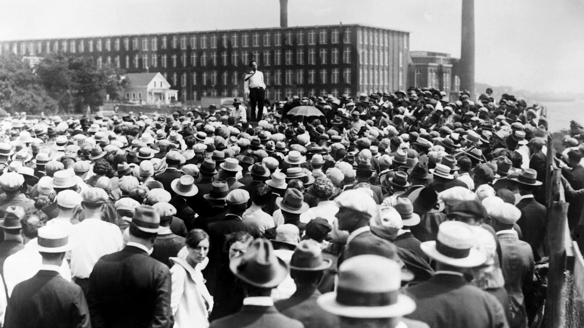 a man standing on a box speaking to a large crowd
